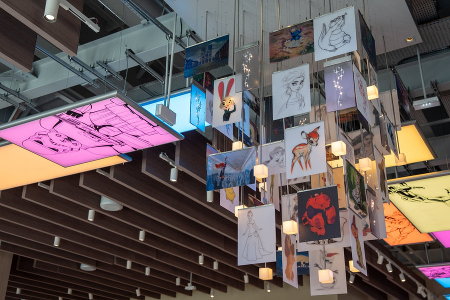 Kroonluchter van Disney Wonders in Disney Village, bestaande uit panelen met Disney-personages en lichtgevende kubussen. Foto © Disneyland Paris.