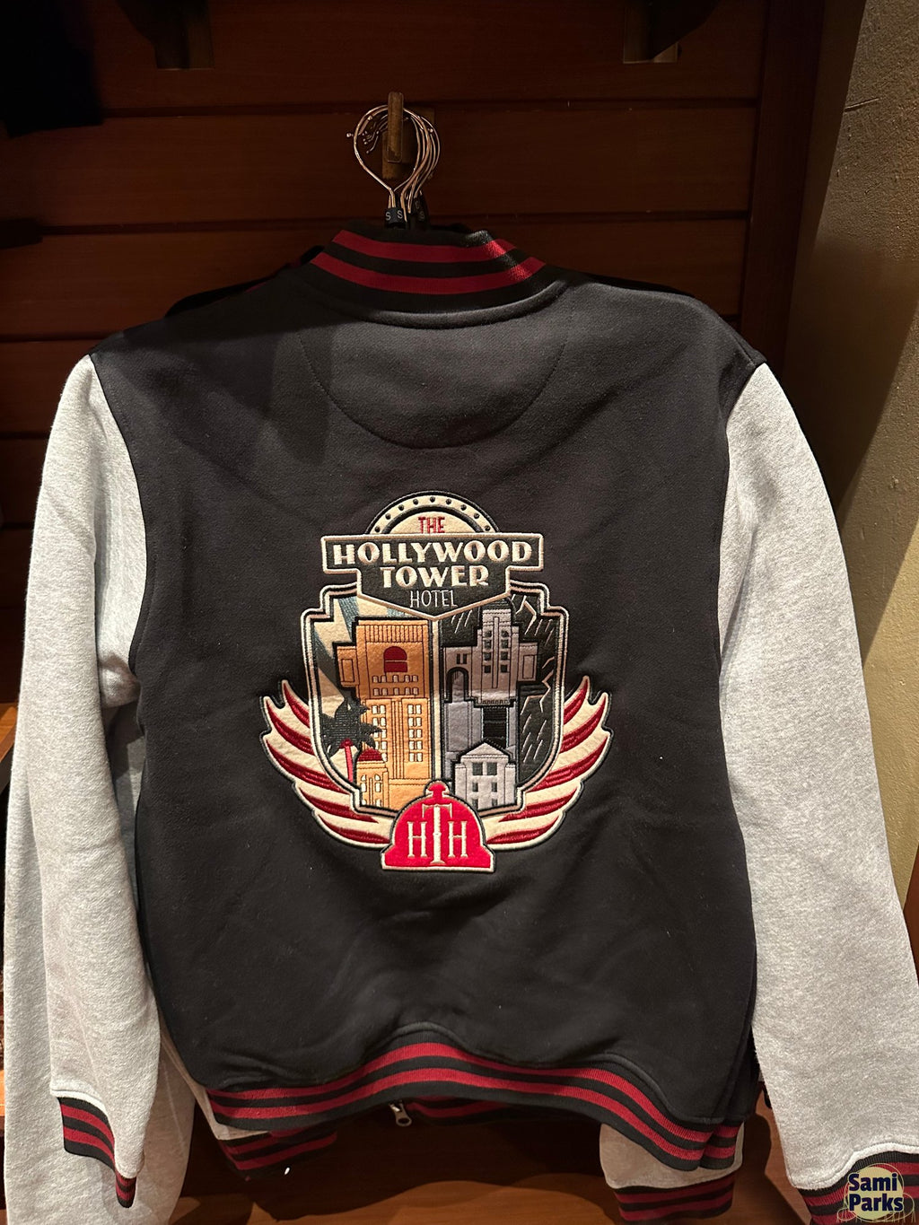 衣架上的惊魂古塔棒球夹克背面，配大型 Hollywood Tower Hotel 徽章图案