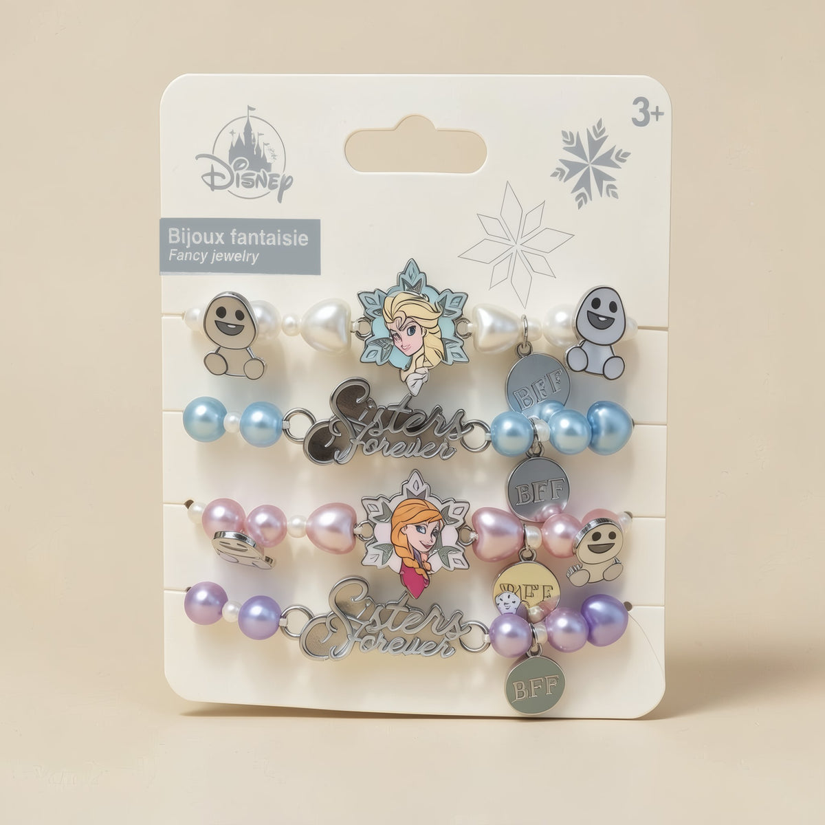 Ensemble de bijoux fantaisie La Reine des Neiges Disneyland Paris sur fond studio beige