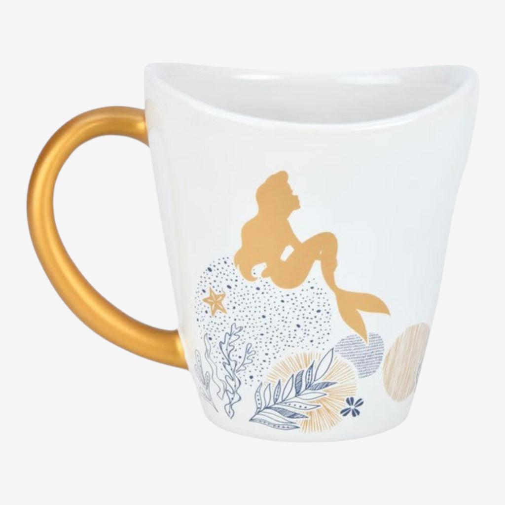 Once Upon Magic white ceramic mug with gold Ariel silhouette, coral reef design, and gold mermaid tail handle.