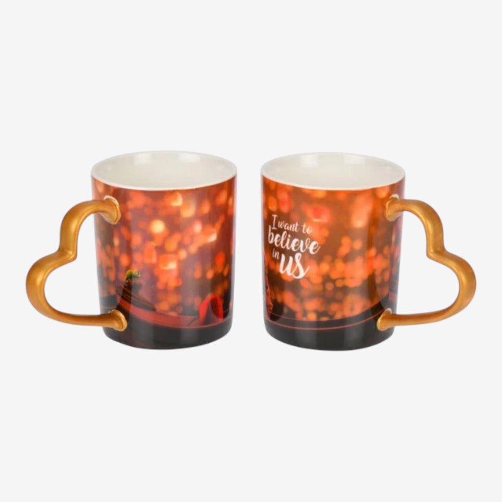 Once Upon Magic ceramic mug with heart-shaped handle, featuring a bokeh light design and "I want to believe in us" quote.