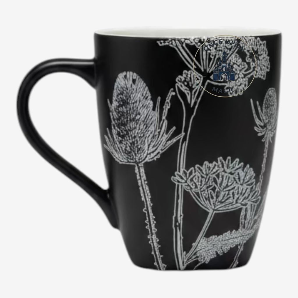 Once Upon Magic Mug Jack featuring a black ceramic mug with a white botanical thistle and wildflower sketch design.