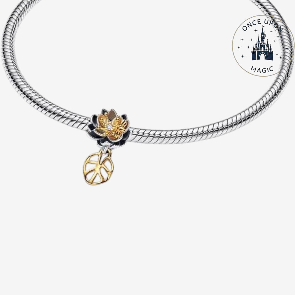 Breloque fleur Once Upon Magic bicolore noire et dorée avec cristal central et feuille ajourée sur bracelet argent.
