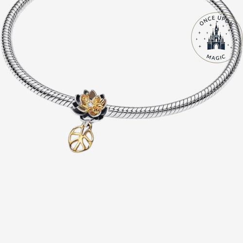 Breloque fleur Once Upon Magic bicolore noire et dorée avec cristal central et feuille ajourée sur bracelet argent.