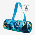 Once Upon Magic character print picnic blanket rolled up with blue carry straps and tropical floral motifs