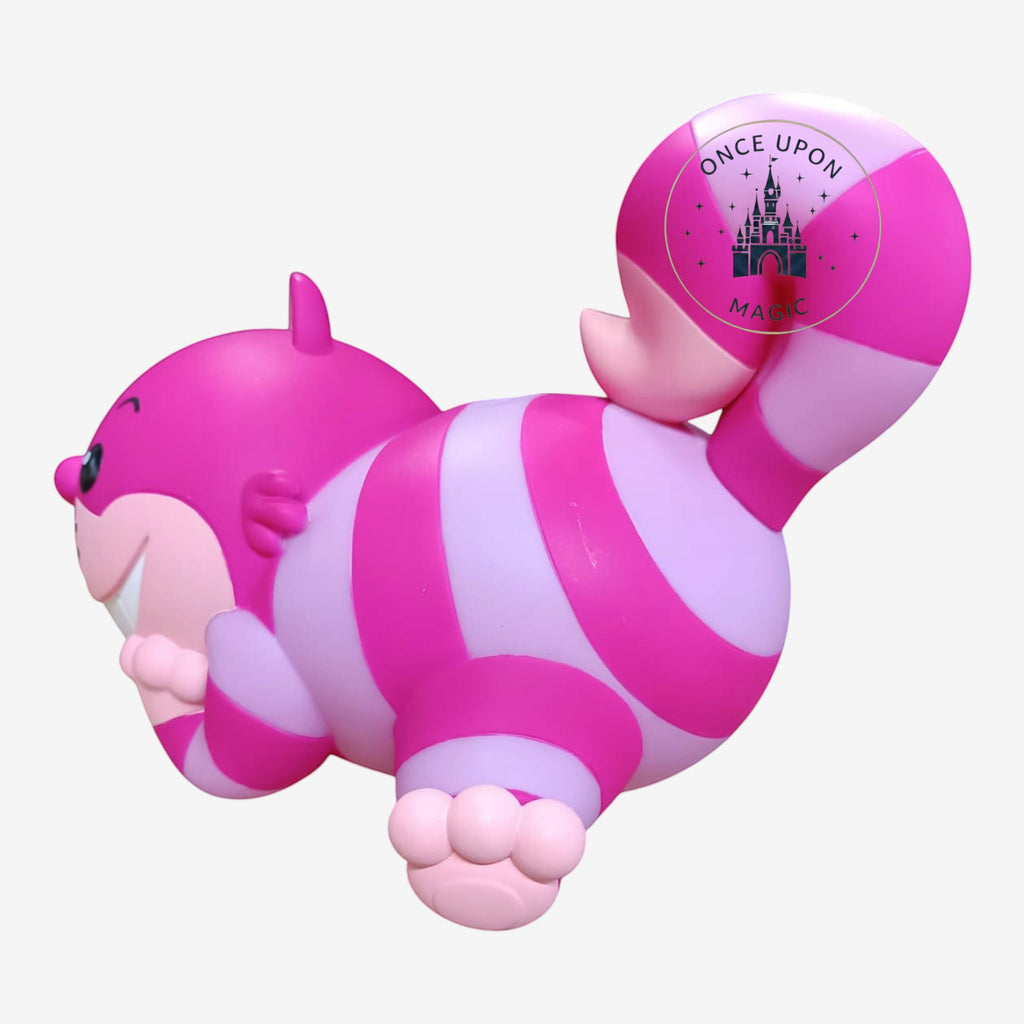 Once Upon Magic Cheshire Cat figurine with vibrant pink and purple stripes and a wide, mischievous toothy grin.