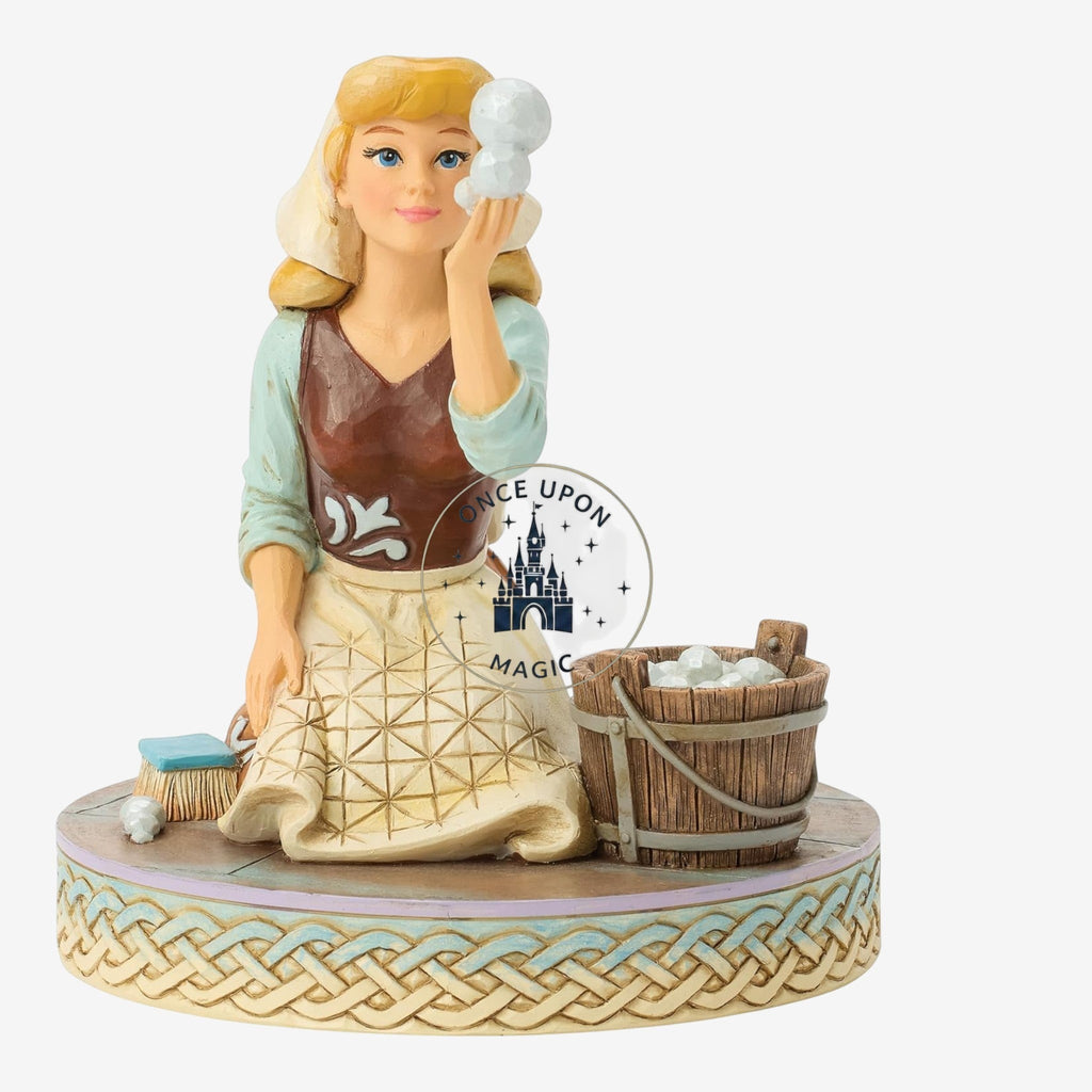 Once Upon Magic Cinderella figurine in scullery maid attire with a wooden bucket and scrubbing brush on a woven base.