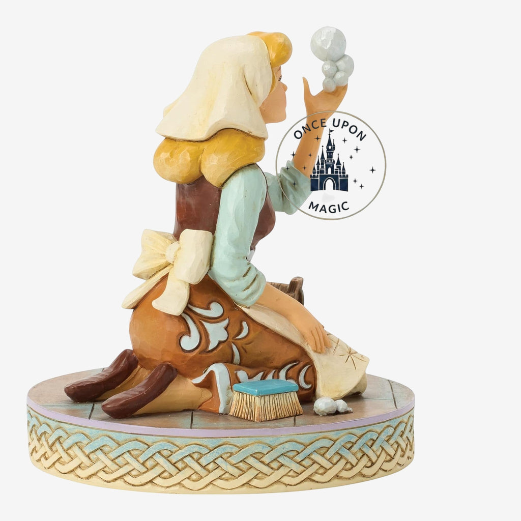 Once Upon Magic Cinderella figurine in scullery maid attire with a scrubbing brush on a decorative woven base