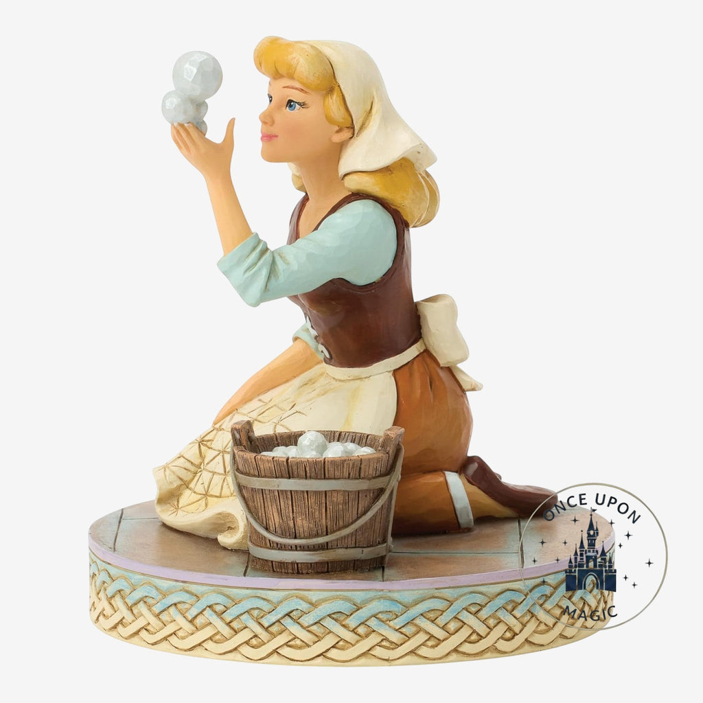 Once Upon Magic Cinderella figurine in scullery maid attire with a wooden bucket on a decorative woven base