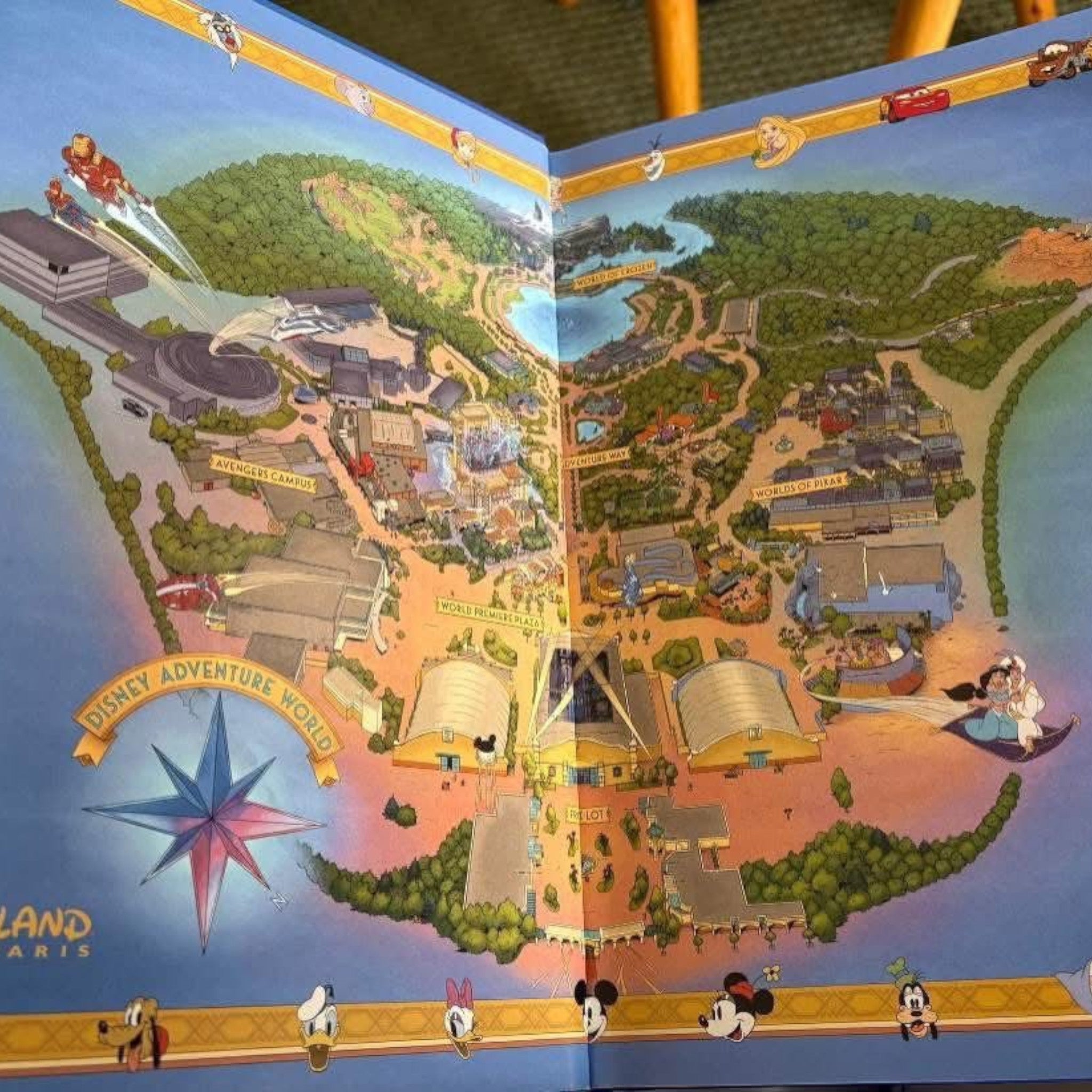 Once Upon Magic Disney Adventure World park map illustration inside a hardcover book featuring iconic characters
