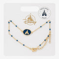 Once Upon Magic Disney gold-tone bracelet with a blue enamel castle charm and dainty blue beads on a display card.