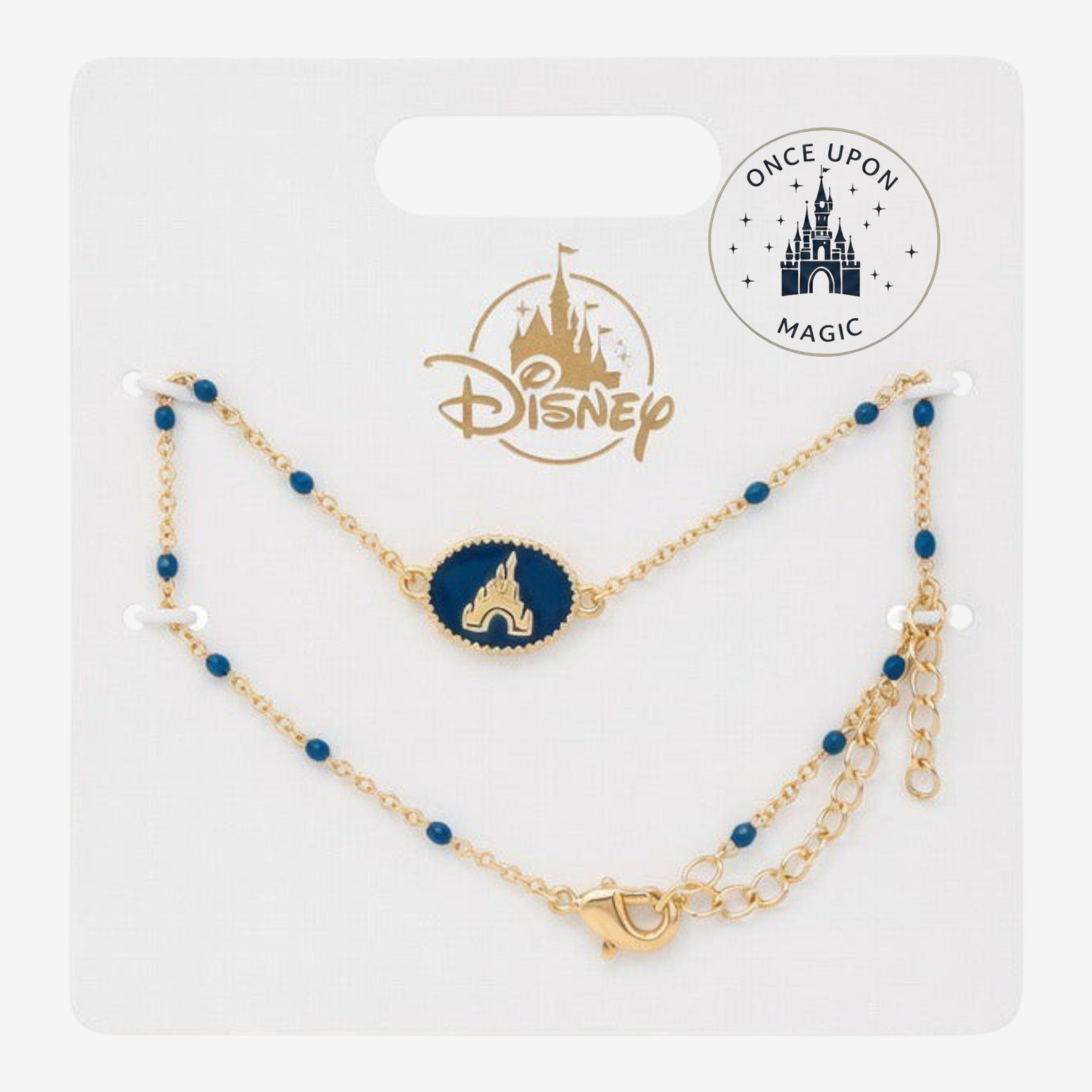 Once Upon Magic Disney gold-tone bracelet with a blue enamel castle charm and dainty blue beads on a display card.