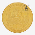Once Upon Magic gold-toned Disneyland Paris It's A Small World commemorative coin with embossed attraction facade.