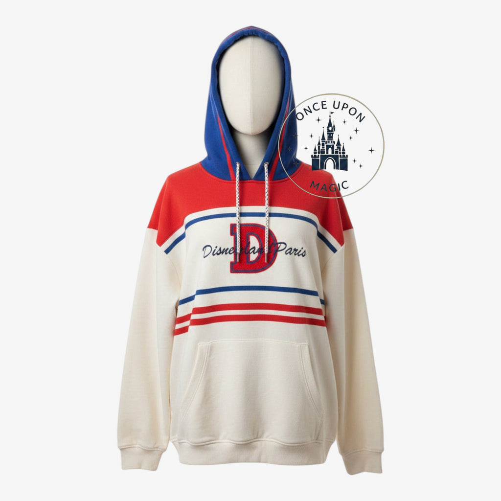 Once Upon Magic Disneyland Paris hooded sweatshirt in cream, red, and blue with a large D logo and front pocket.