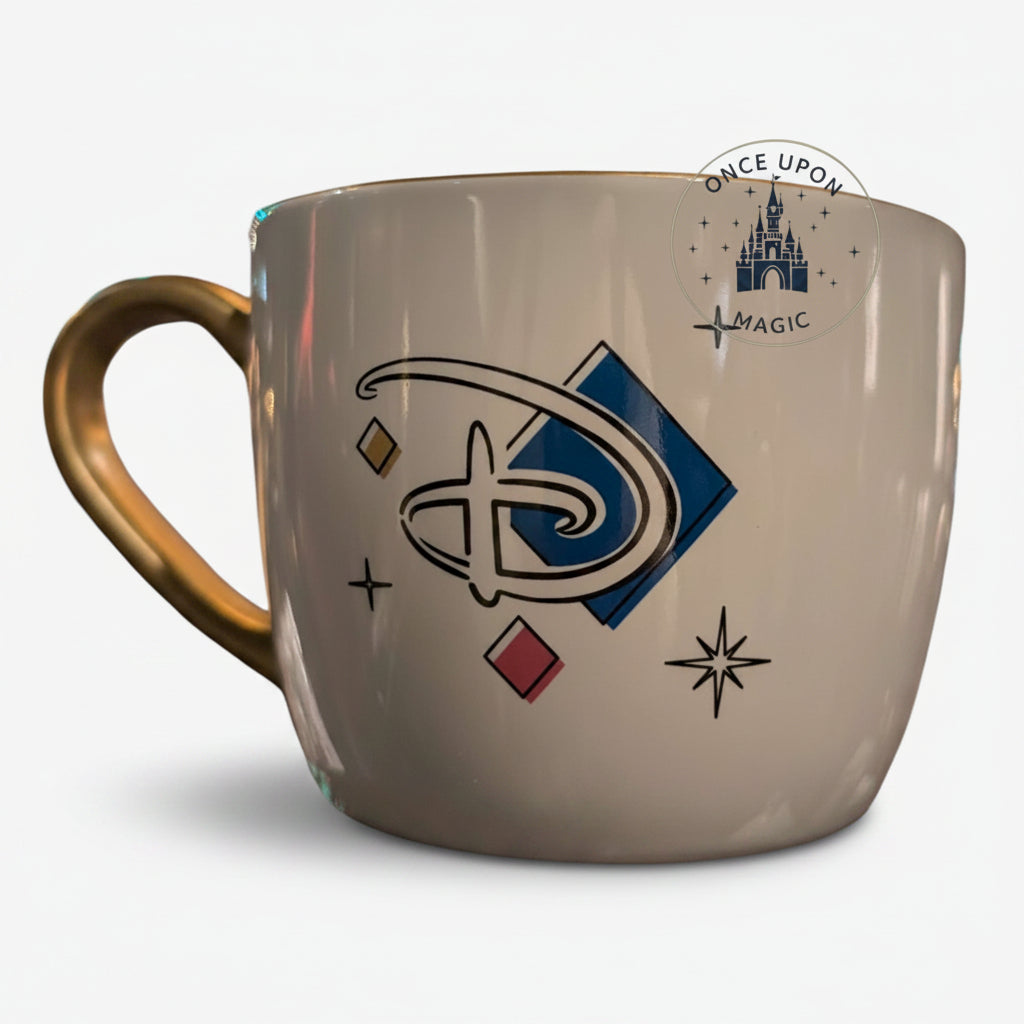 Once Upon Magic white ceramic mug with gold handle, featuring the Disneyland Paris 2024 collection logo and geometric accents.