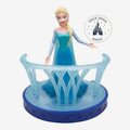 Once Upon Magic Frozen Elsa figurine in an ice-blue gown on a snowflake-themed display stand with a translucent railing.