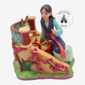 Figurine de collection Once Upon Magic représentant Mulan avec Mushu et Petit Frère, décorée de fleurs de cerisier.