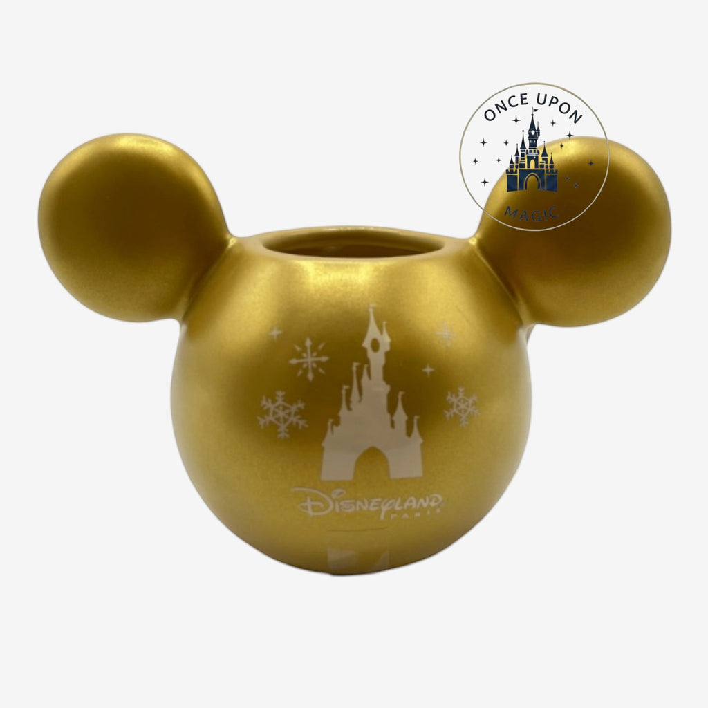 Once Upon Magic gold ceramic mug with iconic ear-shaped design, featuring a Disneyland Paris castle and snowflakes.