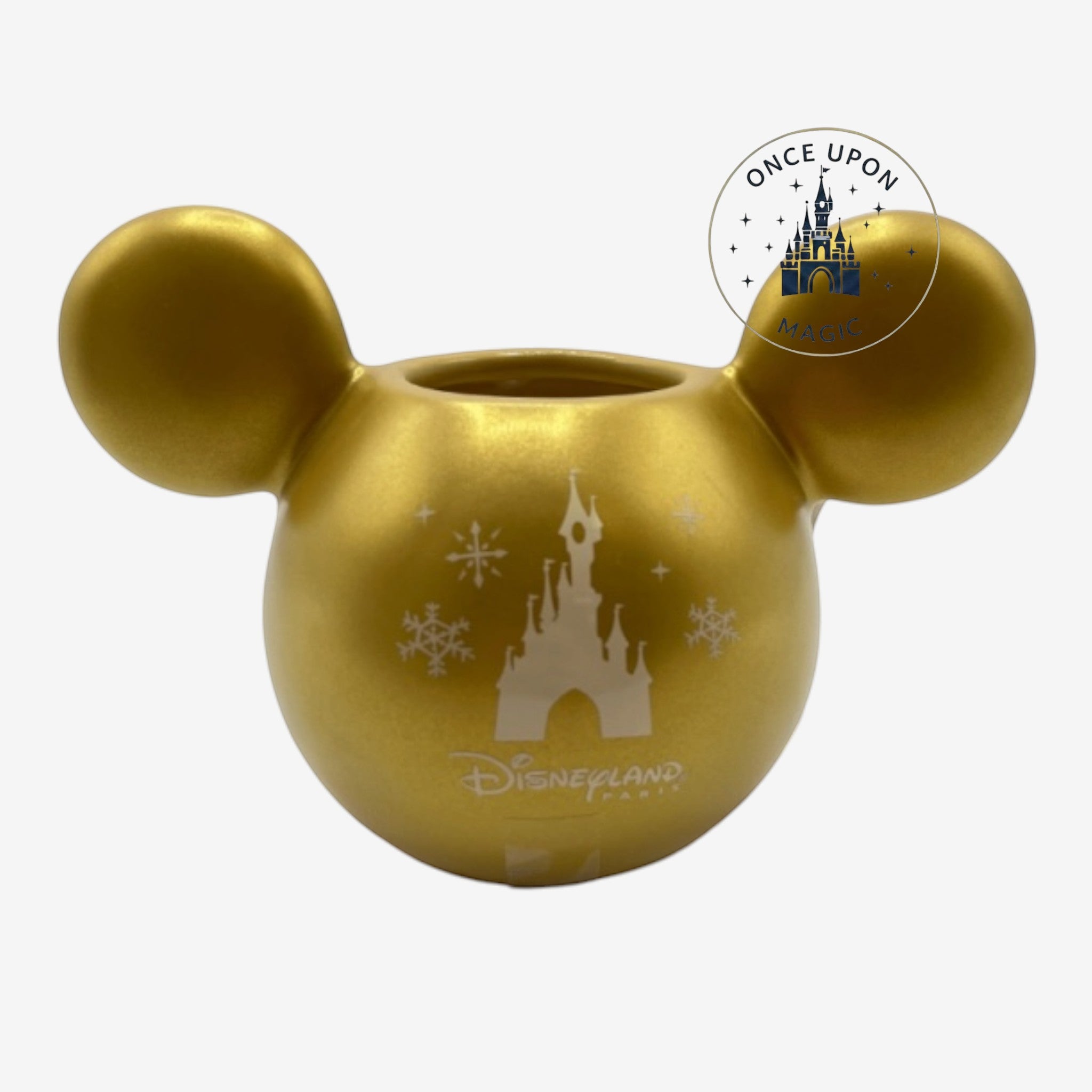 Once Upon Magic gold ceramic mug with iconic ear-shaped design, featuring a Disneyland Paris castle and snowflakes.