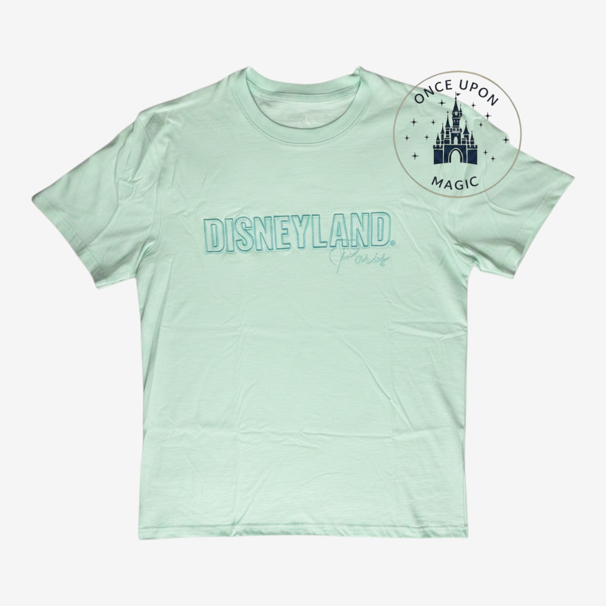 Once Upon Magic mint green cotton crewneck t-shirt featuring the Disneyland Paris logo on the chest.