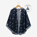 Once Upon Magic navy hooded poncho wrap with light floral pattern, decorative button, and contrasting trim on hanger.
