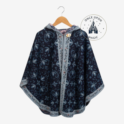 Once Upon Magic navy hooded poncho wrap with light floral pattern, decorative button, and contrasting trim on hanger.