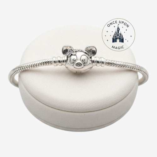 Once Upon Magic silver Pandora Disney Parks charm bracelet with a character clasp on a white display stand.