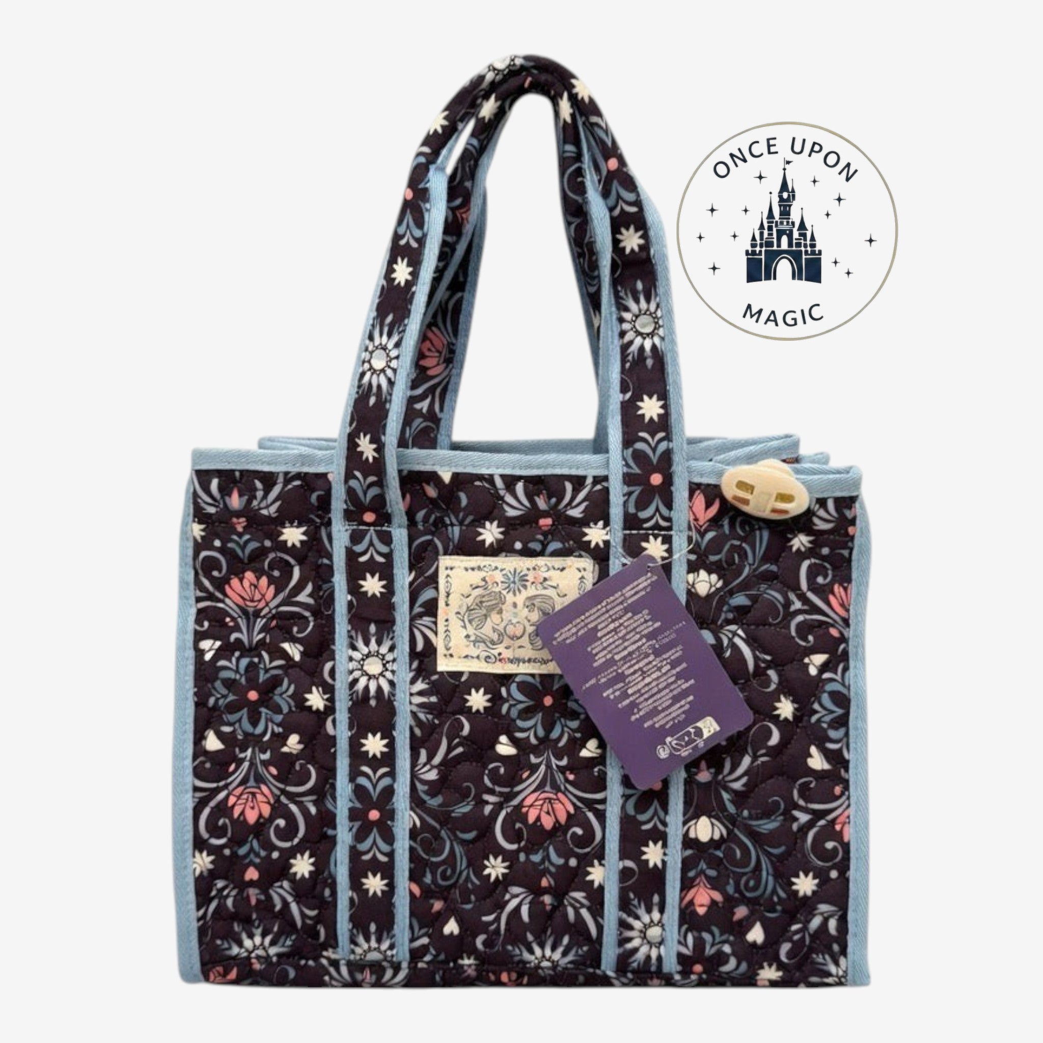 Once Upon Magic quilted floral tote bag with dark base, pink and blue flower print, and light blue trim.