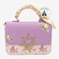 Once Upon Magic Rapunzel crossbody bag with floral print, lavender and pink, gold sun emblem, and satin scarf handle.