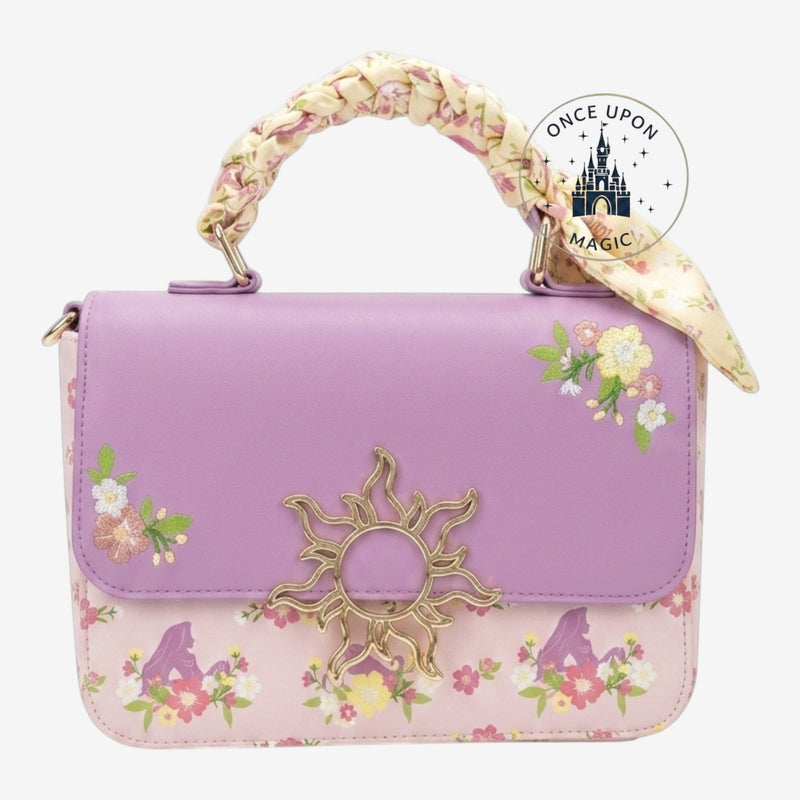 Once Upon Magic Rapunzel crossbody bag with floral print, lavender and pink, gold sun emblem, and satin scarf handle.