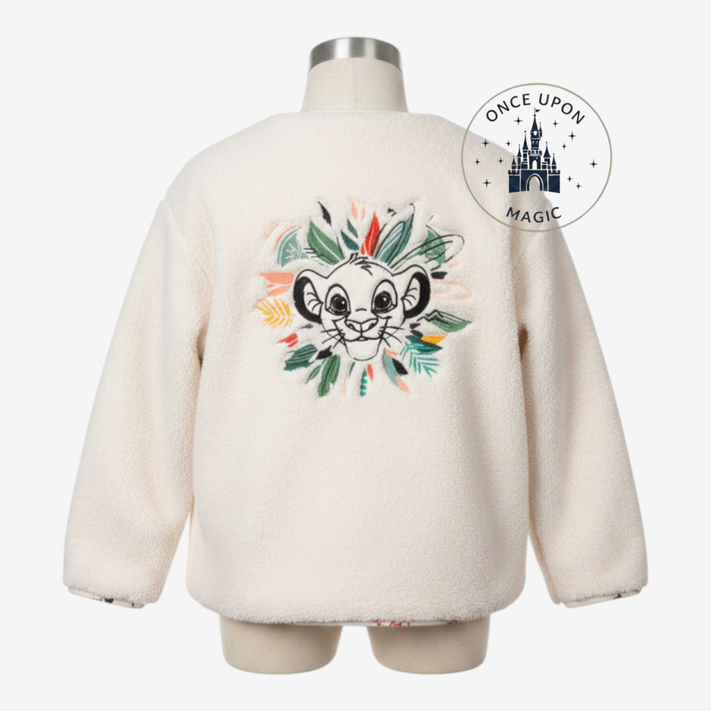 Once Upon Magic cream sherpa jacket featuring a detailed Simba embroidery surrounded by jungle leaves on the back