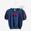 Once Upon Magic Disney Snow White navy blue knit top with puff sleeves and a red bow detail on a white hanger.