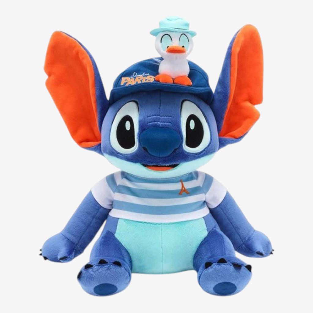 Once Upon Magic blue Stitch plush toy wearing a striped shirt, Paris baseball cap, and a duck accessory.