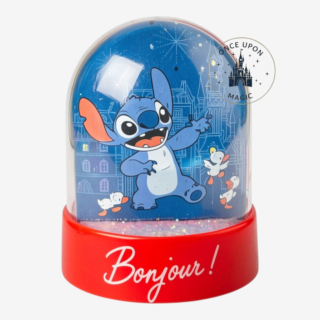 Once Upon Magic blue Stitch snow globe with Paris castle background and "Bonjour!" text on red base.