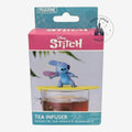 Once Upon Magic blue Stitch tea infuser with yellow surfboard lid on a glass mug of tea.