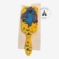 Once Upon Magic yellow paddle hair brush with Stitch character, hibiscus flowers, palm leaves, pineapples, and waves.
