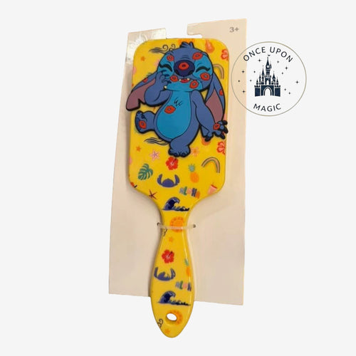 Once Upon Magic yellow paddle hair brush with Stitch character, hibiscus flowers, palm leaves, pineapples, and waves.