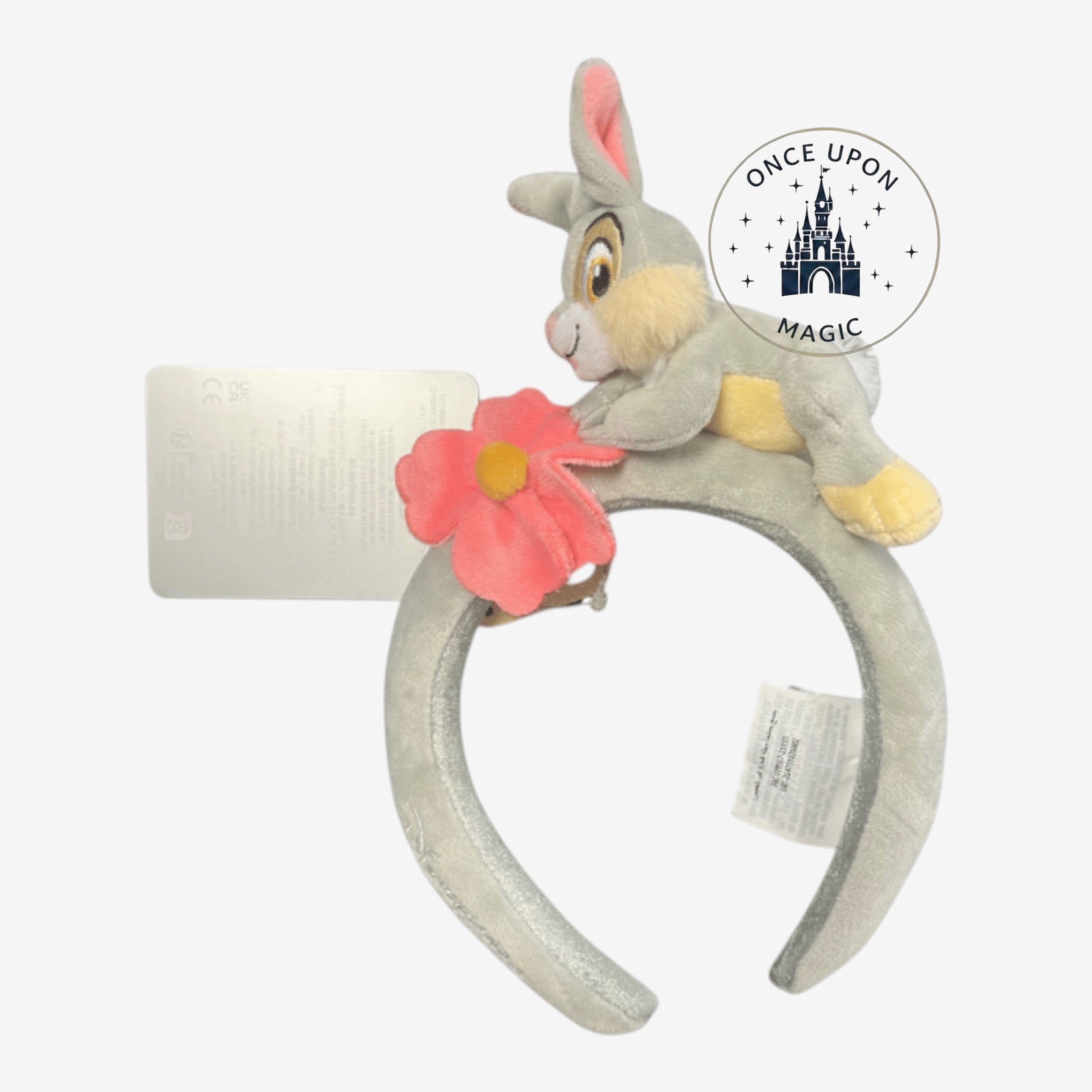 Once Upon Magic Thumper plush headband with a grey bunny figure and a pink flower accent on a velvet-textured band.