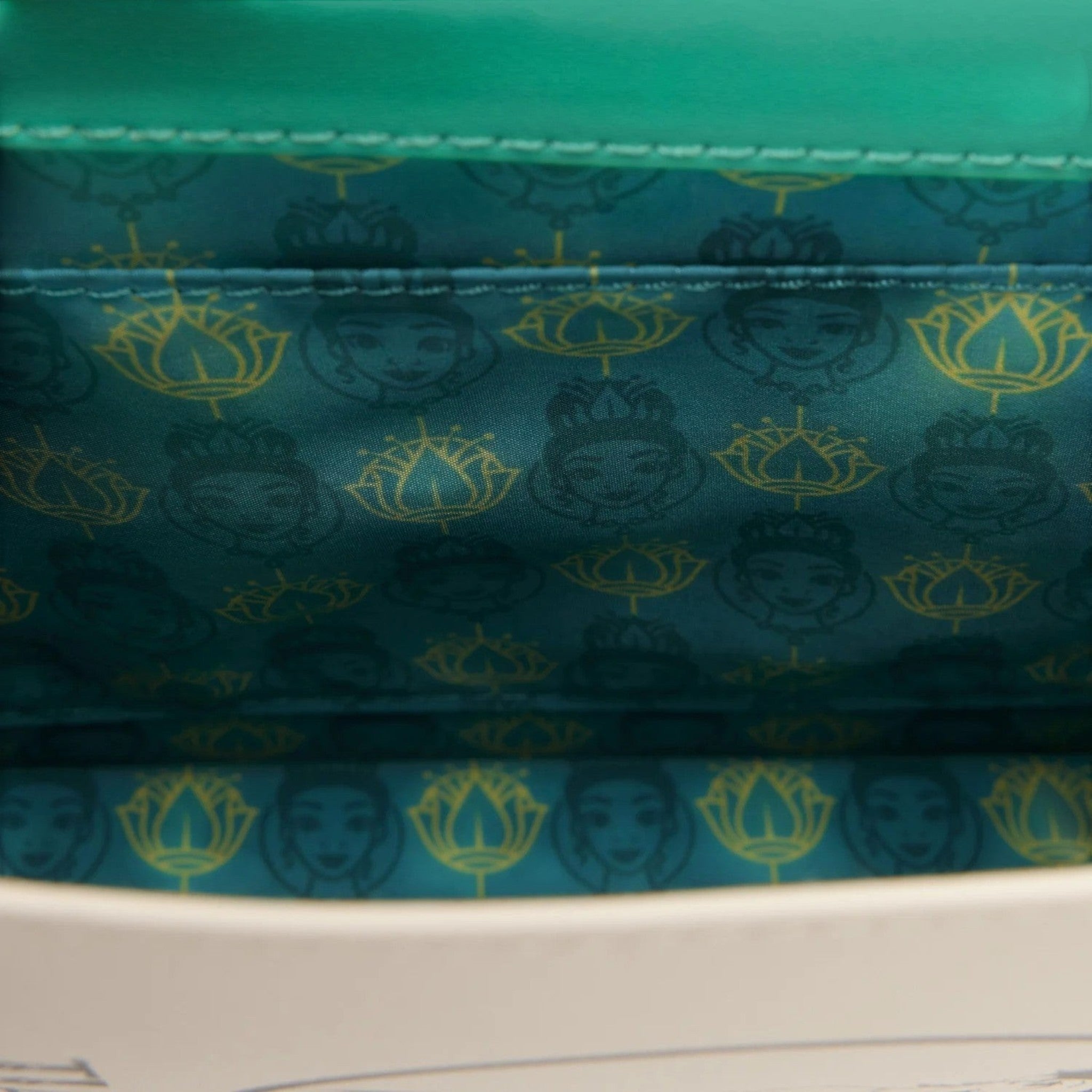 Once Upon Magic Tiana storybook crossbody bag interior with teal lining featuring Princess Tiana and lotus pattern.