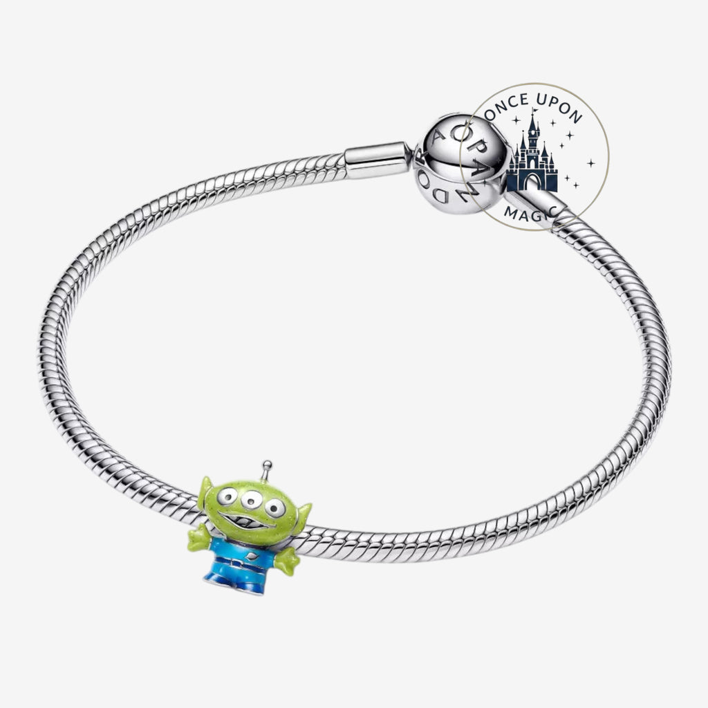 Once Upon Magic Toy Story Alien charm on a silver Pandora-style bracelet. The green alien has three eyes and wears a blue uniform.