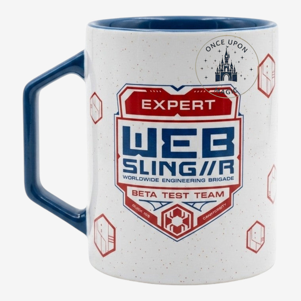 Once Upon Magic white speckled mug with blue handle and rim, featuring a red and blue 'Expert Web Sling'r Beta Test Team' shield graphic.