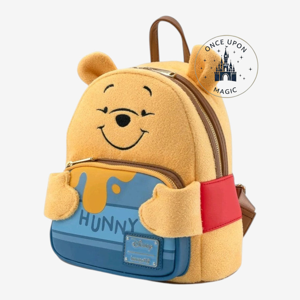 Once Upon Magic Winnie the Pooh mini backpack in fuzzy yellow material with Pooh's face, honey pot pocket, and red band.