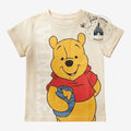 Once Upon Magic cream cotton t-shirt for kids featuring Winnie the Pooh with a honey pot and a small bee graphic.