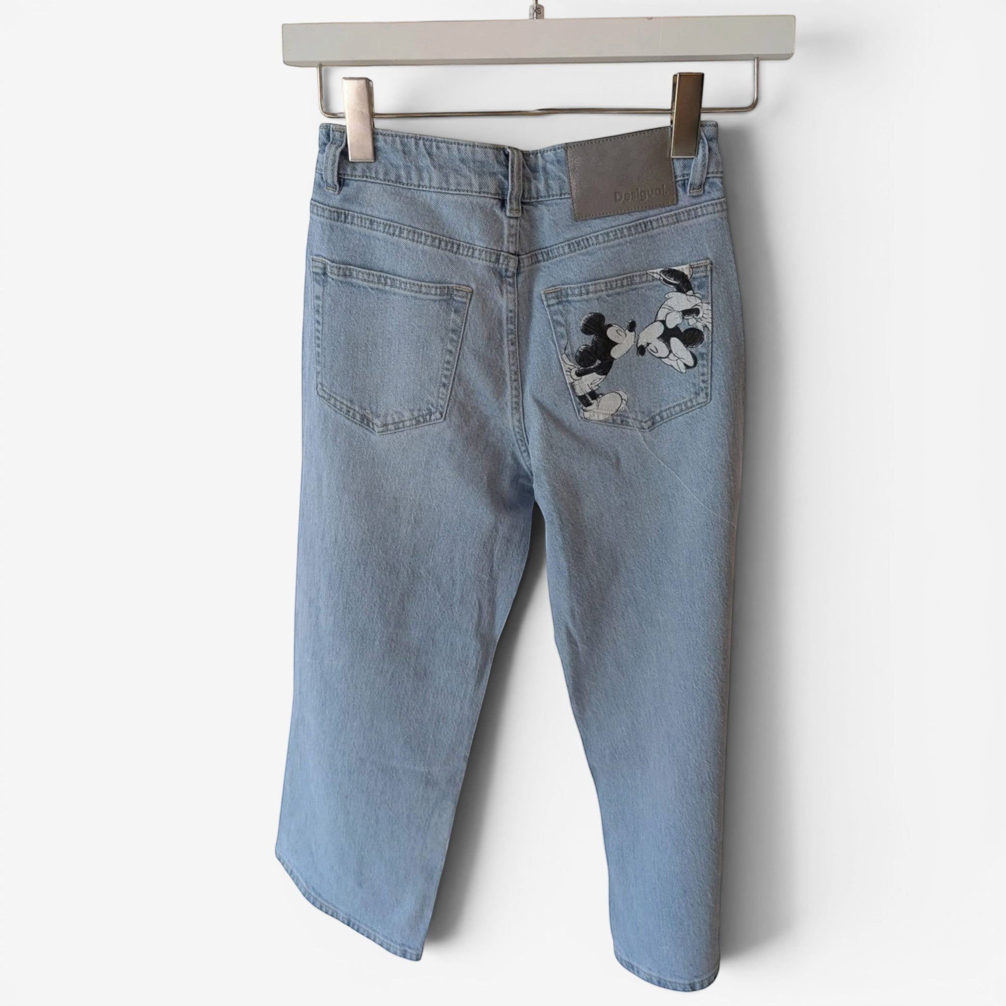 Light wash denim jeans by Desigual x Disneyland Paris featuring Mickey Mouse graphic on back pocket. Straight leg, mid-rise.