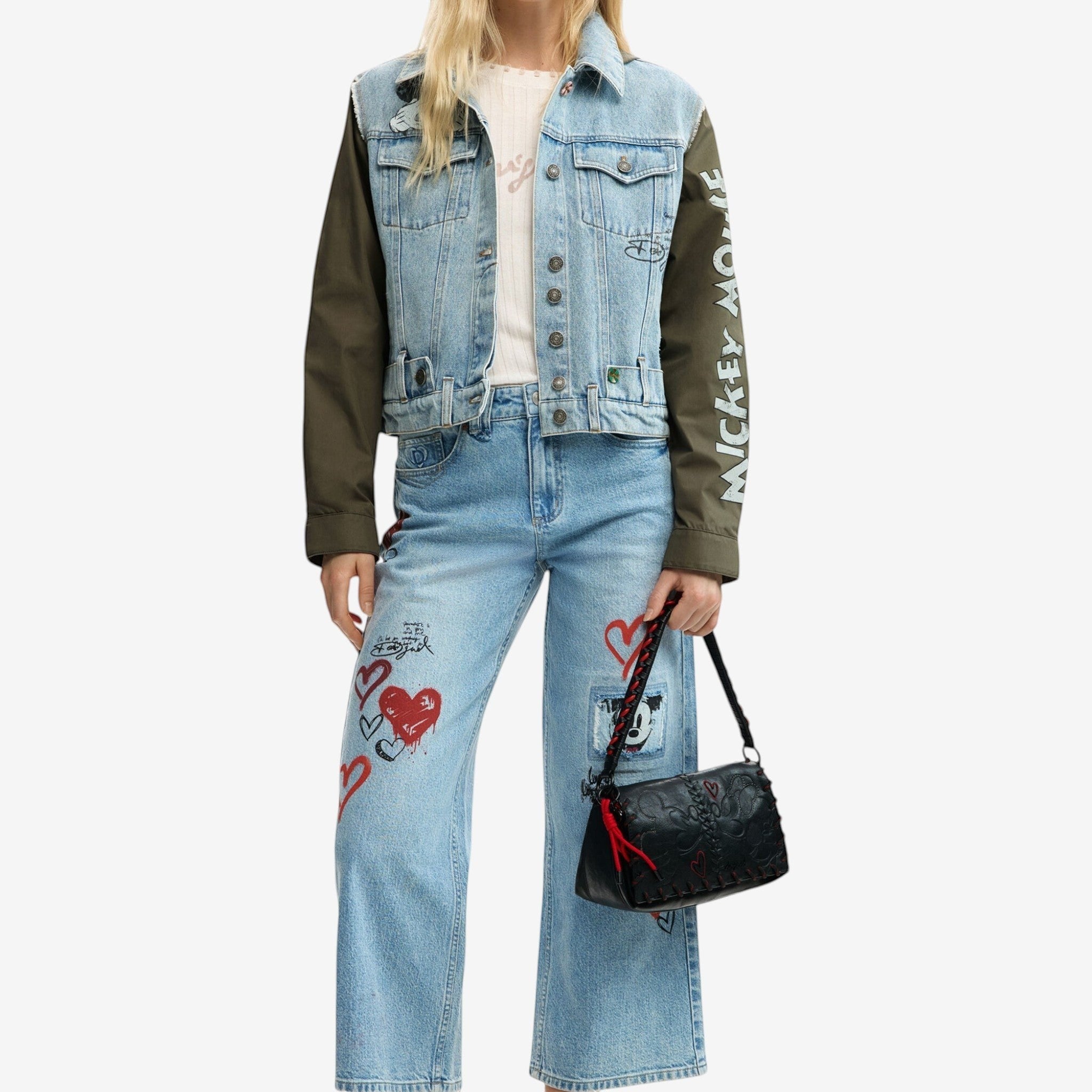 Once Upon Magic x Disneyland Paris denim jacket with khaki sleeves, Mickey Mouse print, and graphic details. Worn by a model with matching jeans.