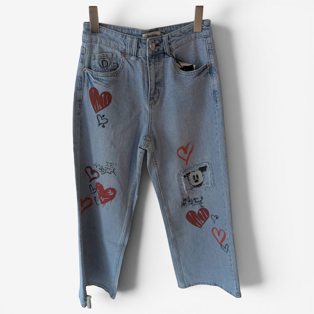 Once Upon Magic light wash denim jeans with red heart graphics and a Mickey Mouse patch. Relaxed fit.
