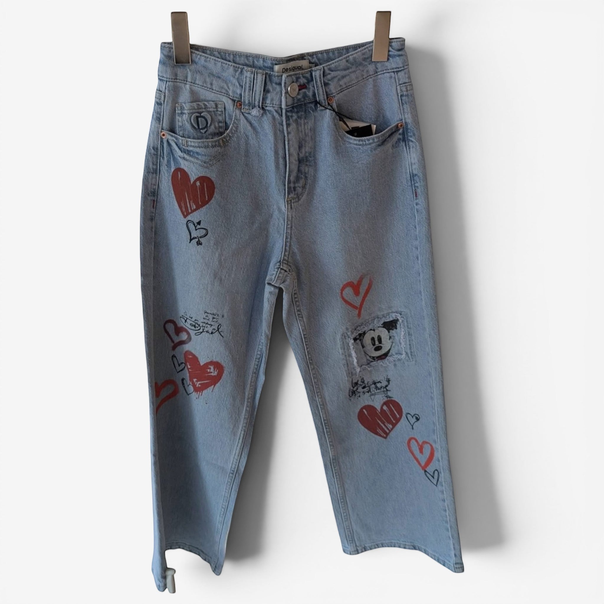 Once Upon Magic light wash denim jeans with red heart graphics and a Mickey Mouse patch. Relaxed fit.