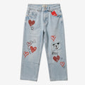 Once Upon Magic light wash denim jeans with red heart prints and a Mickey Mouse patch. Straight leg, mid-rise.