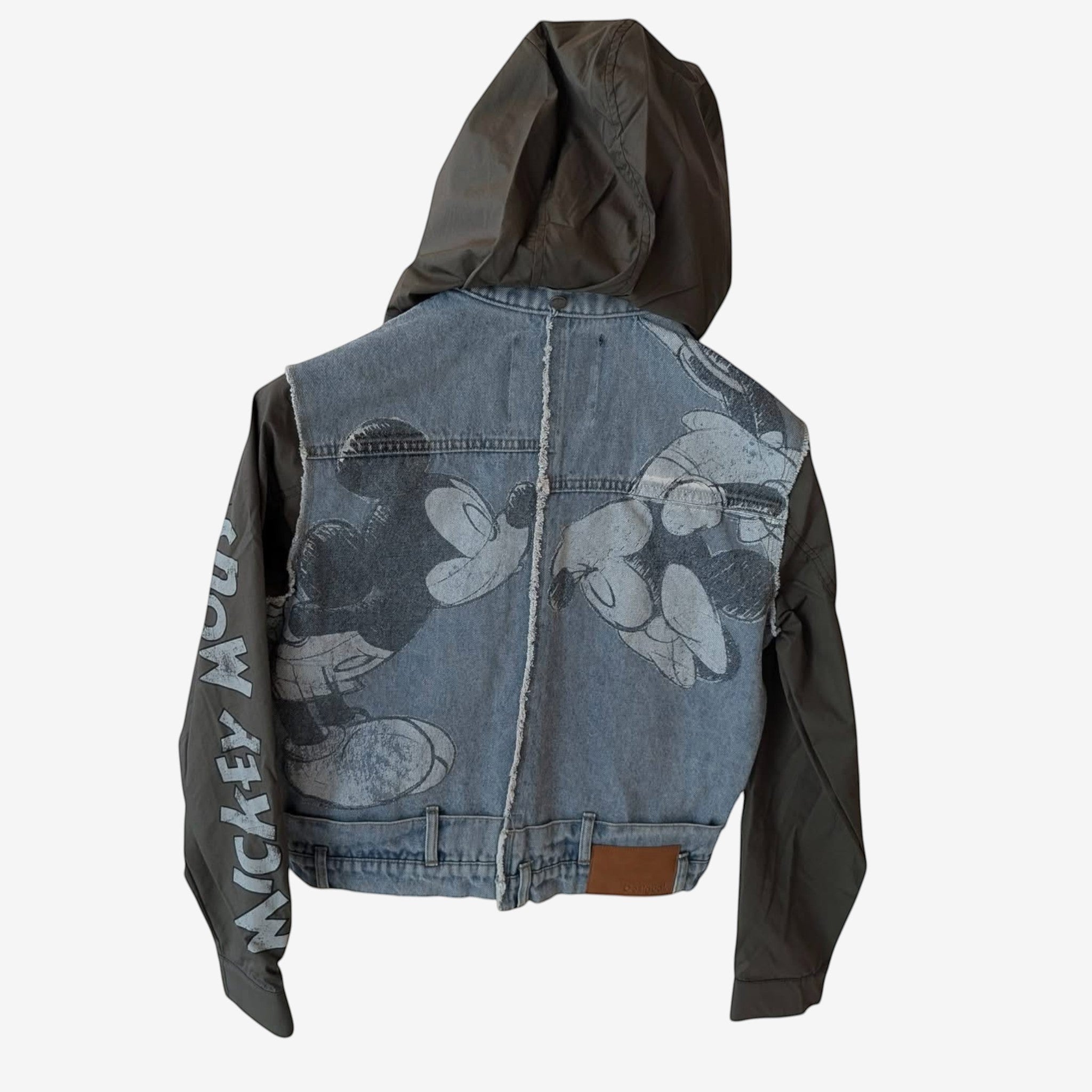 Once Upon Magic x Disneyland Paris denim jacket with Mickey Mouse graphic print and olive green sleeves and hood.