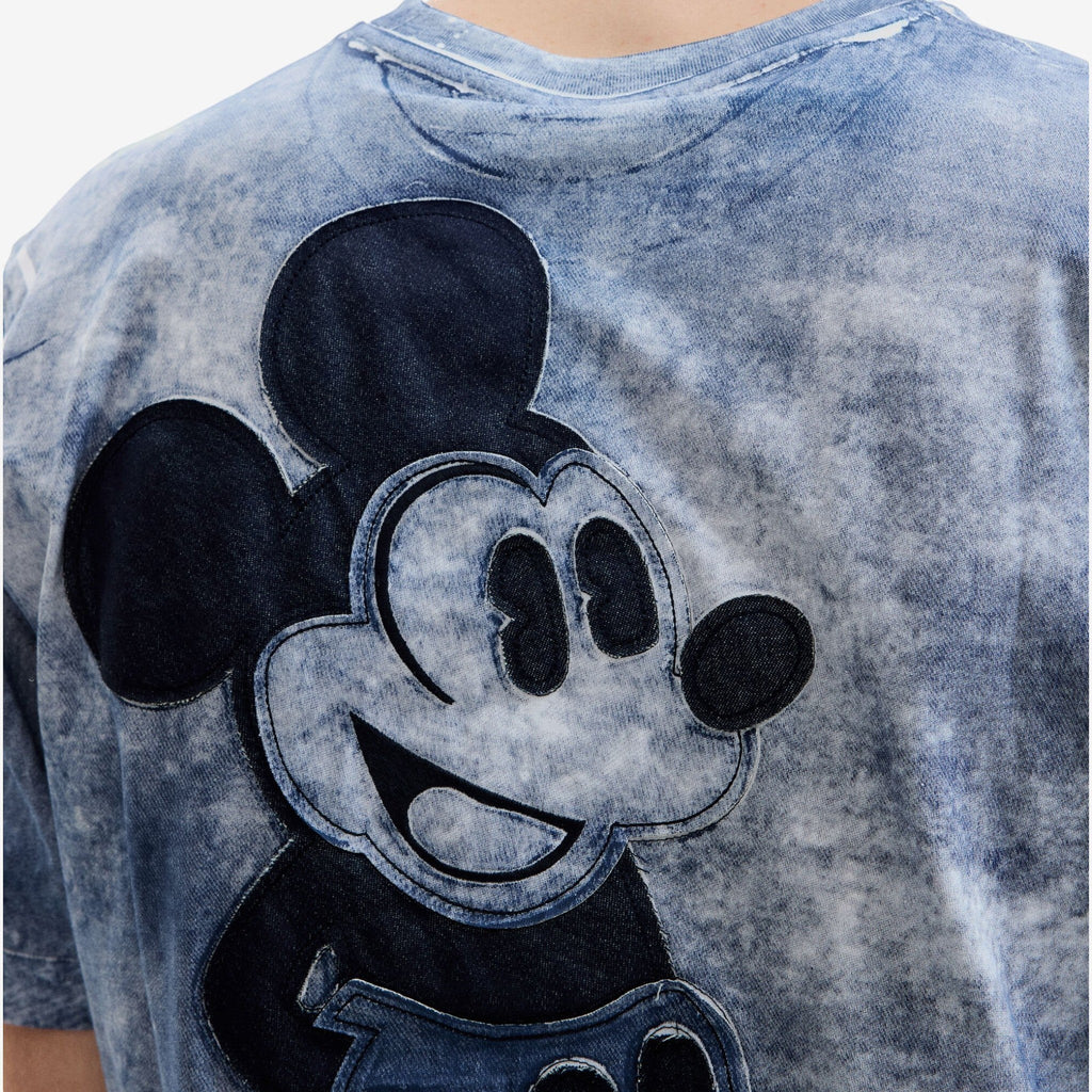 Once Upon Magic t-shirt with a distressed blue wash and a large Mickey Mouse appliqué made of dark denim.